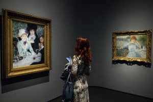 Egy látogató éppen Renoir Ebéd után című festményét tekinti meg. Fotó: MTI/Hegedüs Róbert